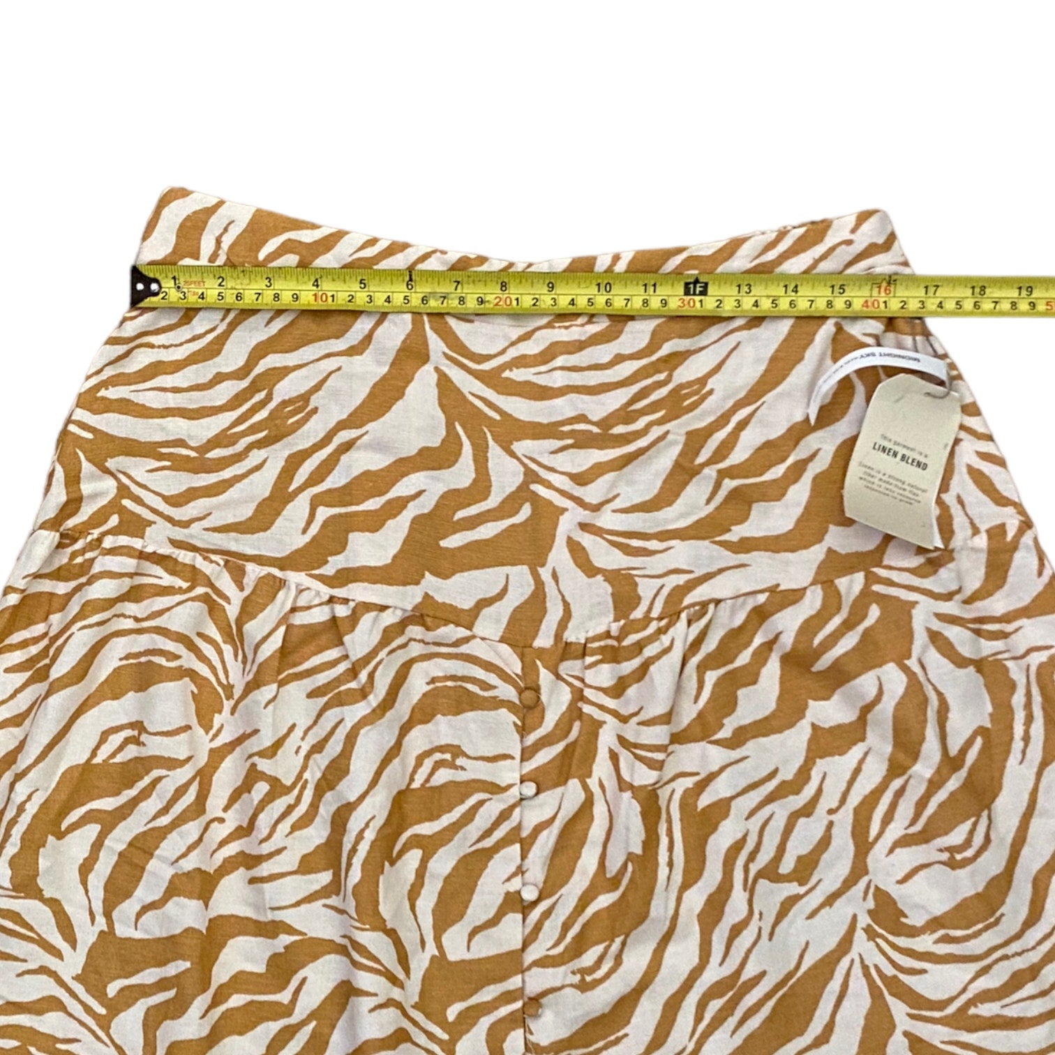 Skirt with brown and white pattern and measuring tape on a white background