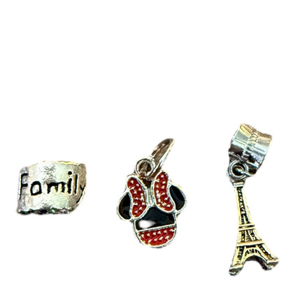 Three charms on a white background: one with 'Family' text, another with red and black design, and a third resembling the Eiffel Tower.
