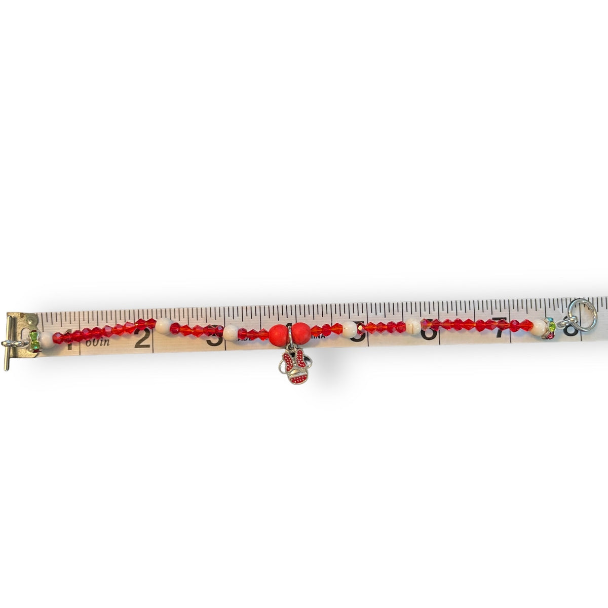 A beaded bracelet , displayed horizontally on a measuring tape against a white background.