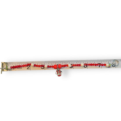 A beaded bracelet , displayed horizontally on a measuring tape against a white background.