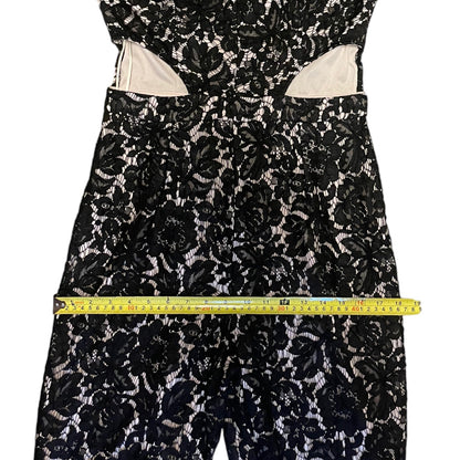 Black floral lace dress with a measuring tape on a white background