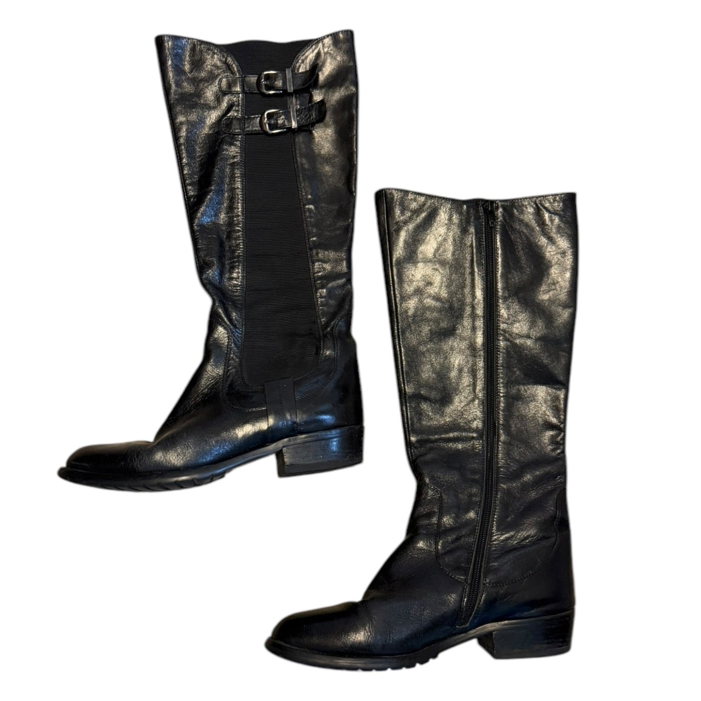 Side view of a Pair of black leather knee-high boots on a white background