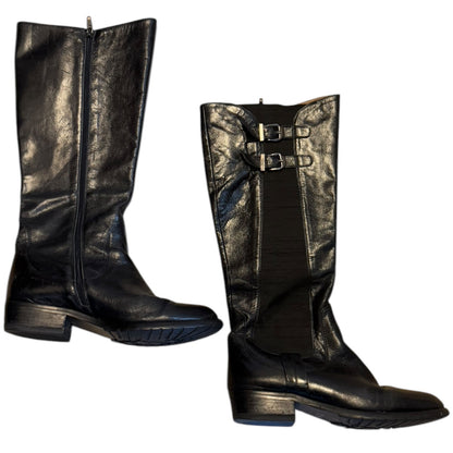 Side view of a Pair of black leather knee-high boots with buckles on a white background