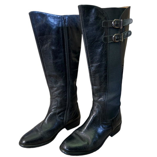 Front side of Pair of black knee-high boots with buckles on a white background