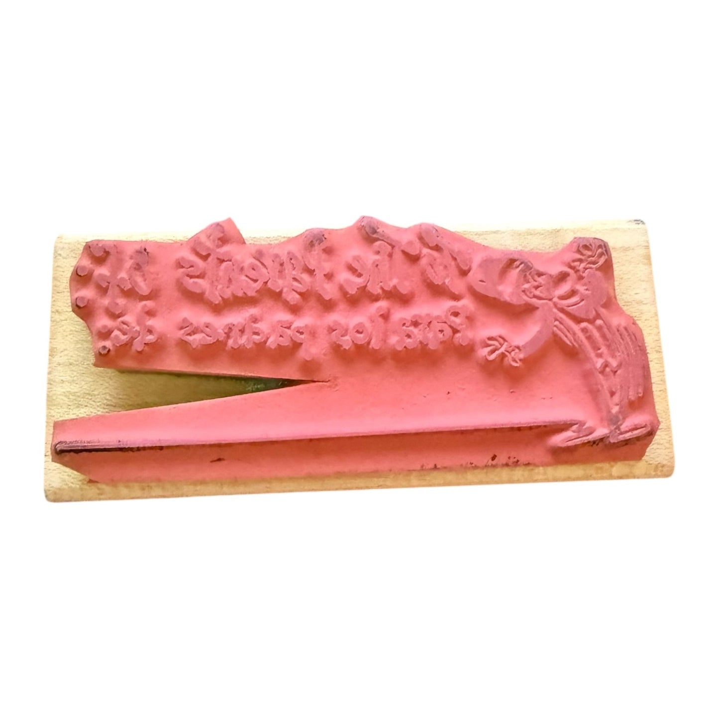 Decorative pink stamp with to the parents of design on a wooden block against a white background