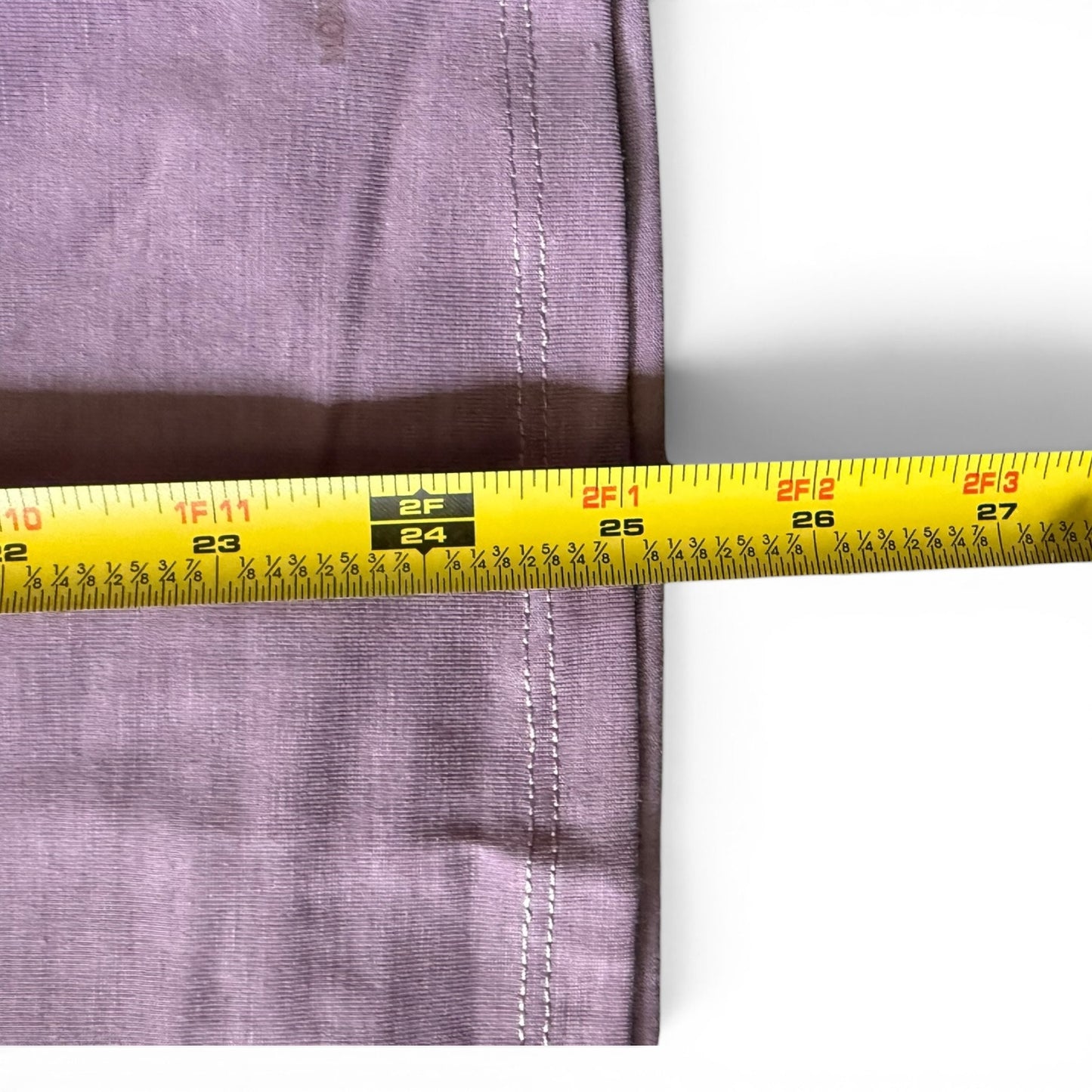 Purple shirt with a yellow measuring tape close up on a white background. 