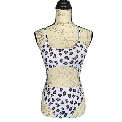 A sleeveless white monokini with a brown and black leopard print pattern, displayed on a beige script-printed dress form mannequin against a white background.