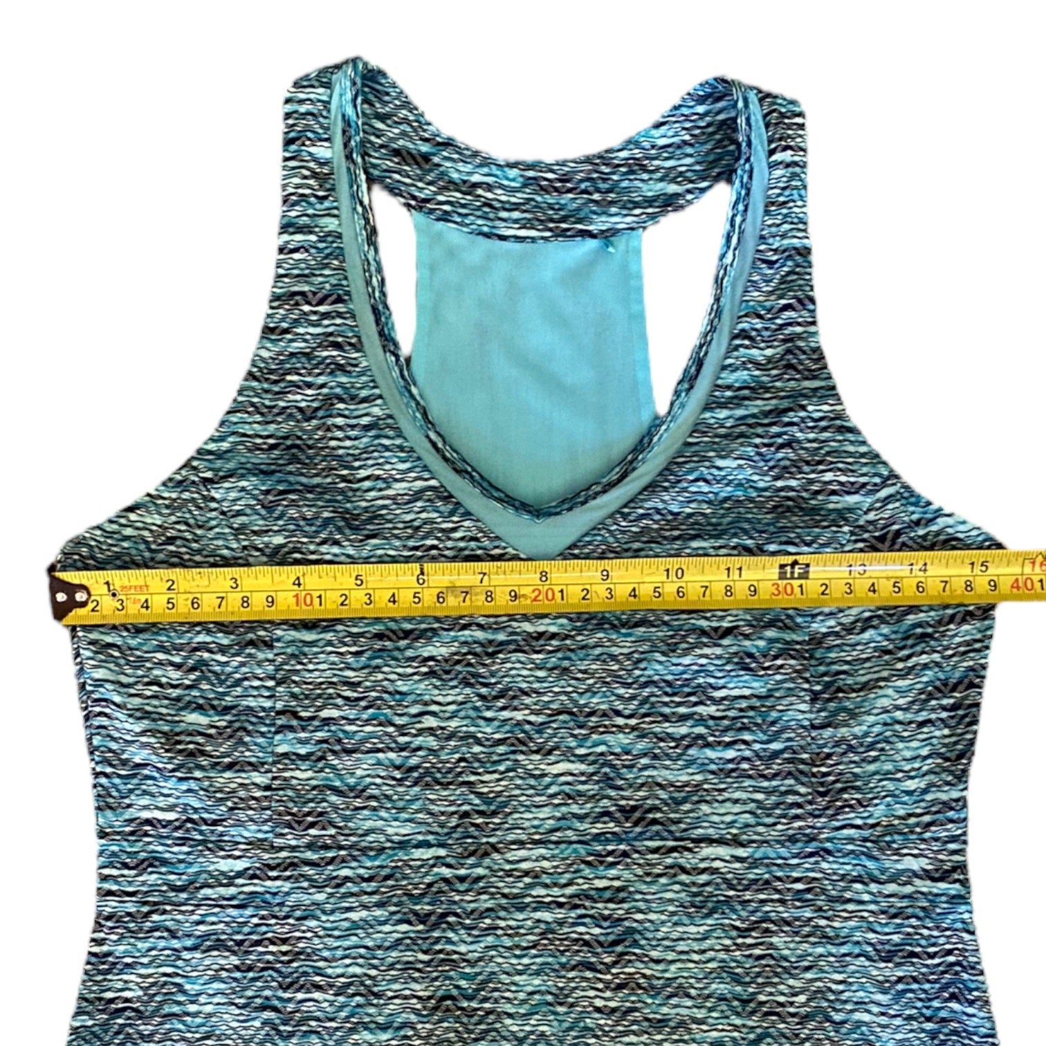 Blue dress with a yellow tape measure across the chest on a white background