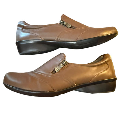Side view Pair of brown leather shoes with gold zippers on a white background