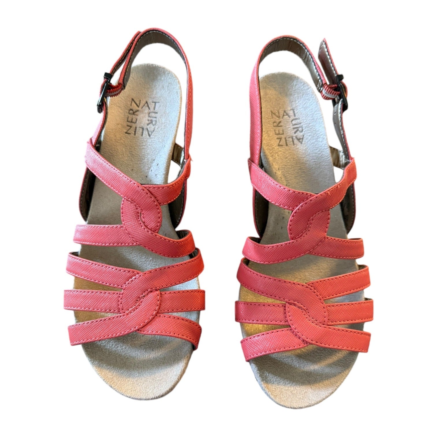 Pair of orange sandals with a white background