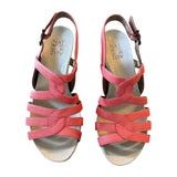 Pair of orange sandals with a white background