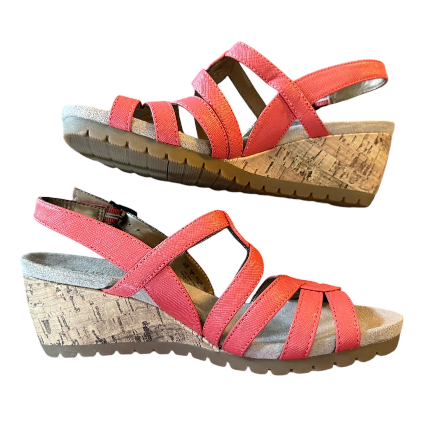 Pair of coral orange wedge sandals on a white background