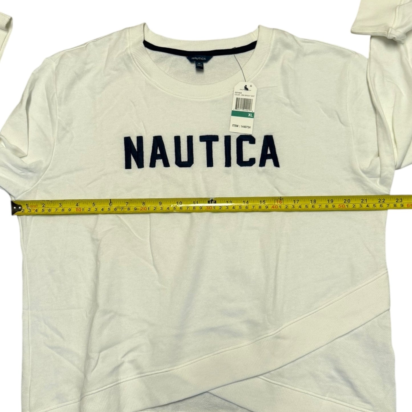 White Nautica shirt with a measuring tape and tags on a white background