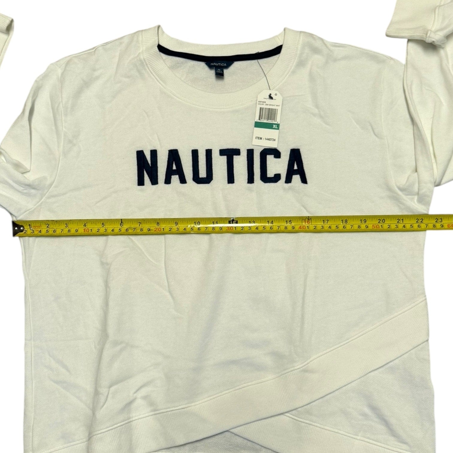 White Nautica shirt with a measuring tape and tags on a white background