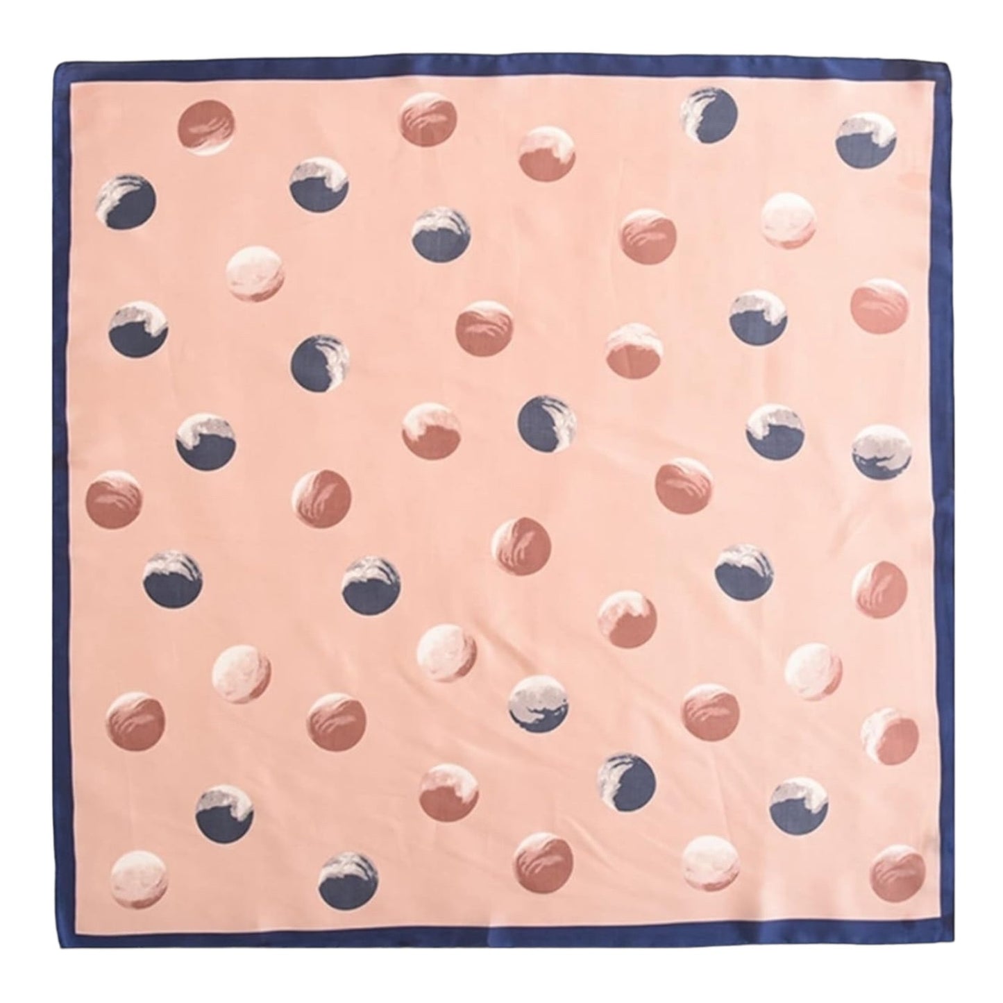 A square scarf with a pink background, decorated with a pattern of textured polka dots in terracotta, navy, and white, finished with a solid navy blue border.