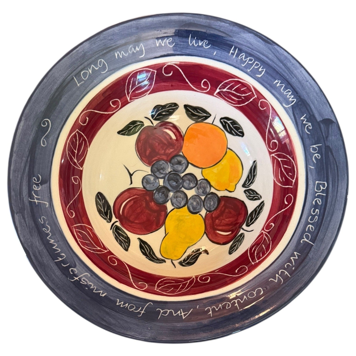 Decorative plate with fruit design and text on a white background