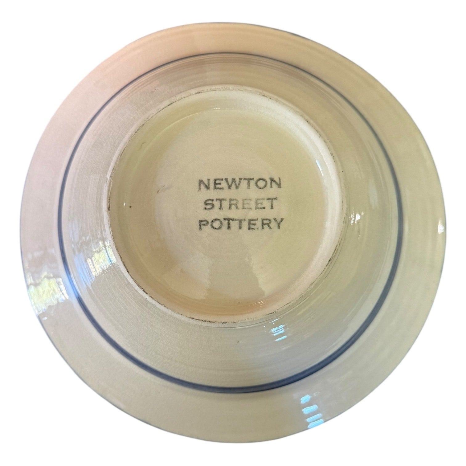 Bottom of Ceramic bowl with 'Newton Street Pottery' branding on a white background
