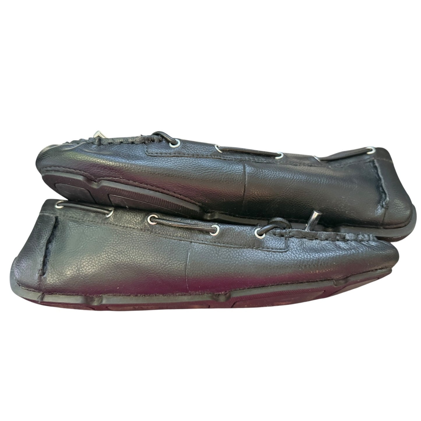A pair of black leather moccasin-style  loafers with silver metal eyelets and stitching, shown against a plain white background.