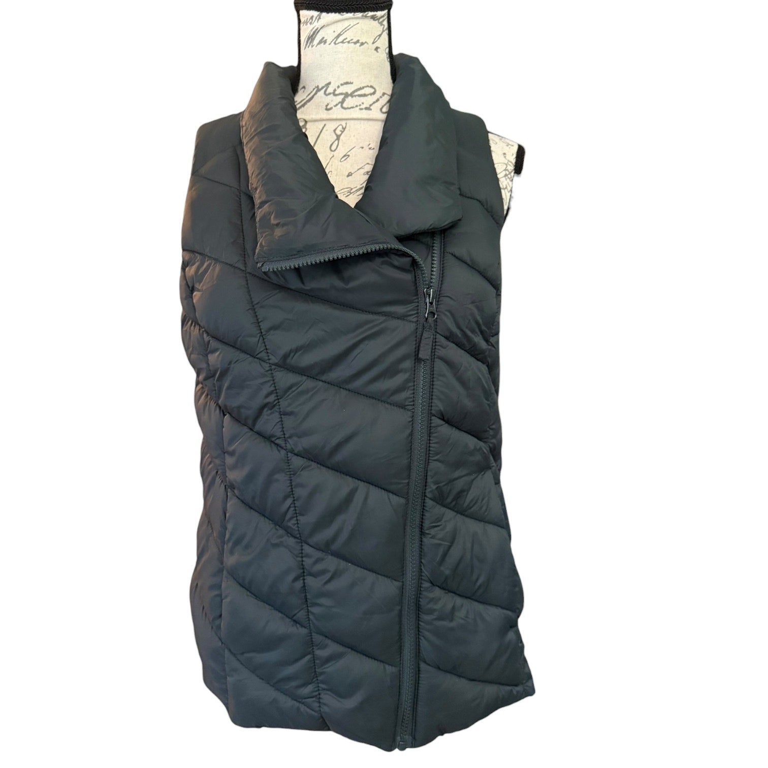 Front of Dark green puffer vest on a mannequin with a white background