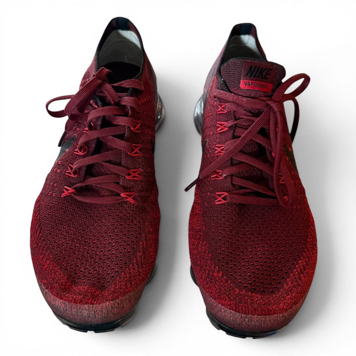 A pair of Nike Air Zoom X Flyknit running shoes in a deep burgundy red, shown from a top-down angle on a white background.
