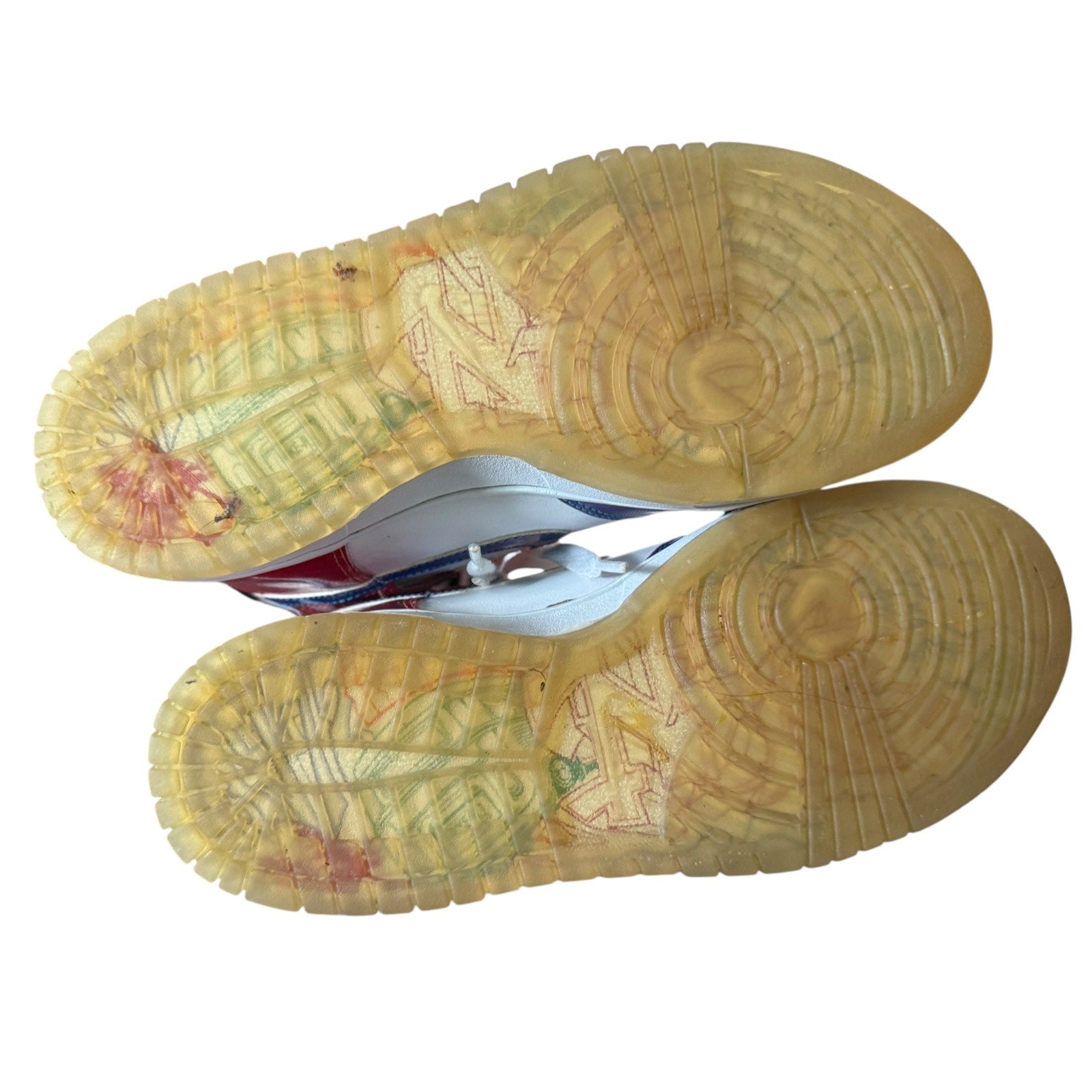 Close-up of a worn sneaker sole with visible wear and tear on a white background