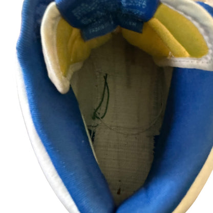 Close-up interior of a blue and yellow shoe with a brand label on a white background