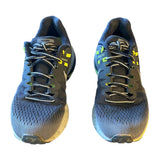 Front of Pair of black running shoes with yellow accents on a white background