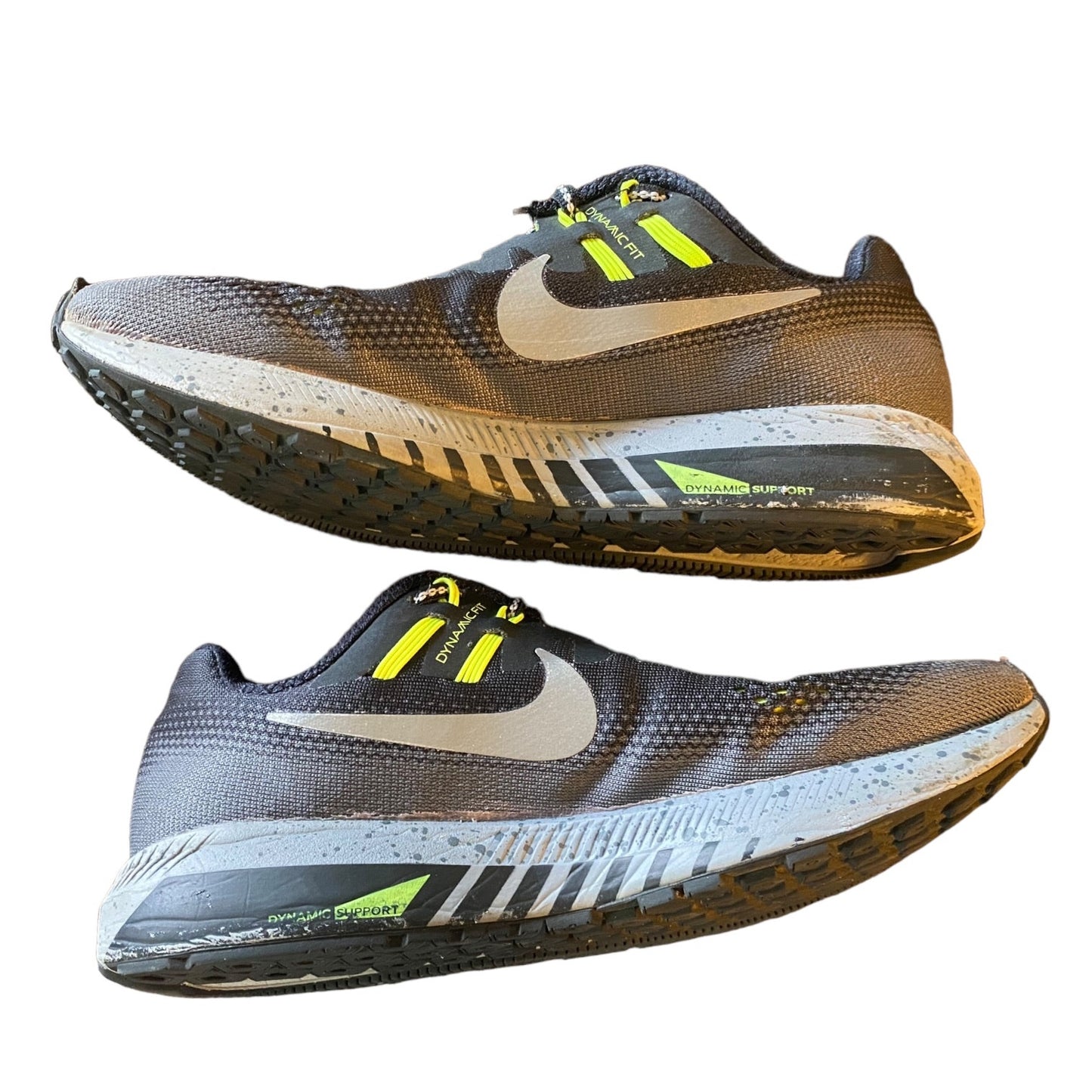 Side of running shoes with yellow accents on a white background