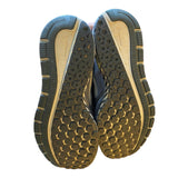 Close-up of a pair of shoes with a focus on the sole design on a white background