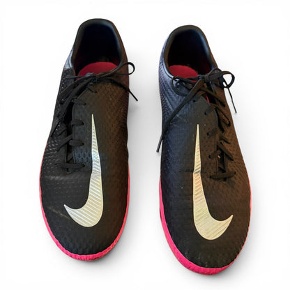 Black soccer shoes with pink soles and white Nike swoosh logo on a white background