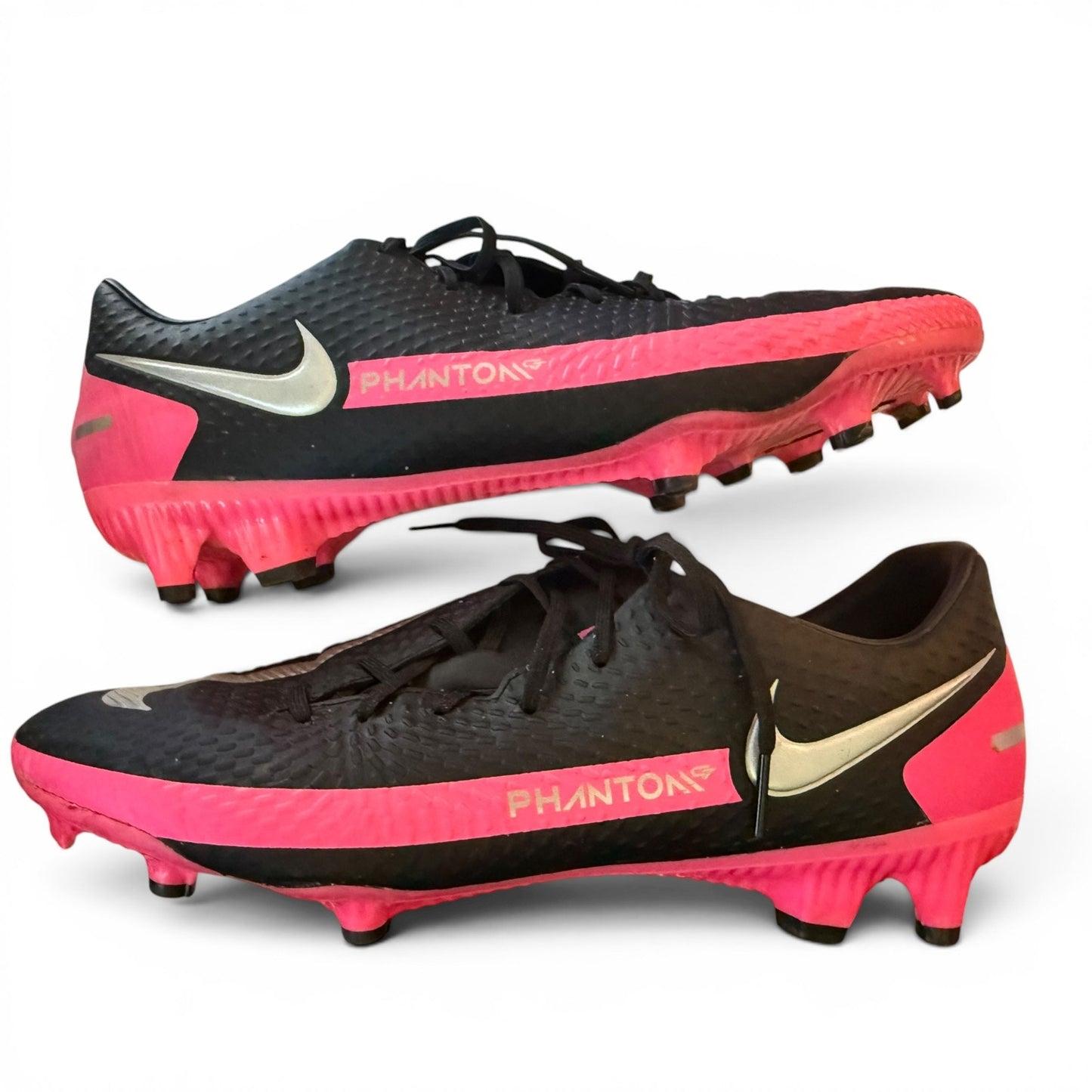 Pair of black and pink soccer cleats with 'Phantom' branding on a white background