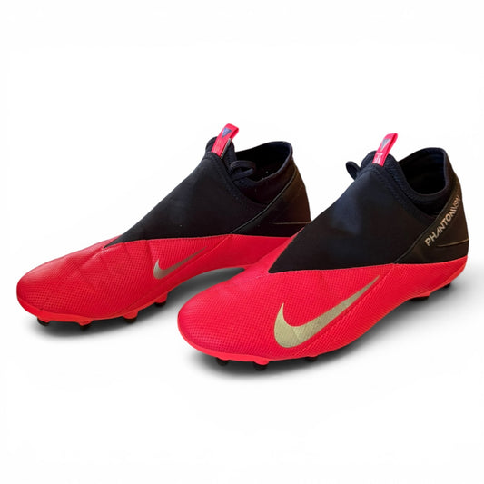Red and black soccer cleats with Nike logo on a white background