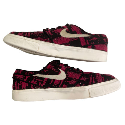 Pair of black and pink patterned sneakers with a white Nike logo on a white background