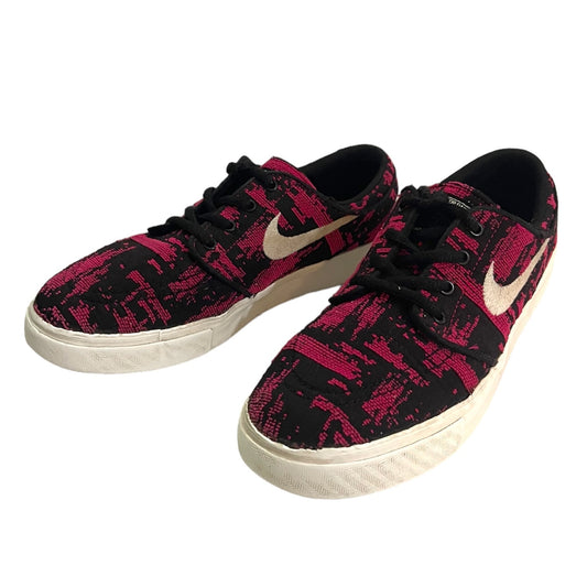 Black and pink patterned sneakers with a swoosh logo on a white background