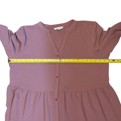 Pink dress with a measuring tape around it on a white background