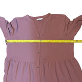 Pink dress with a measuring tape around it on a white background