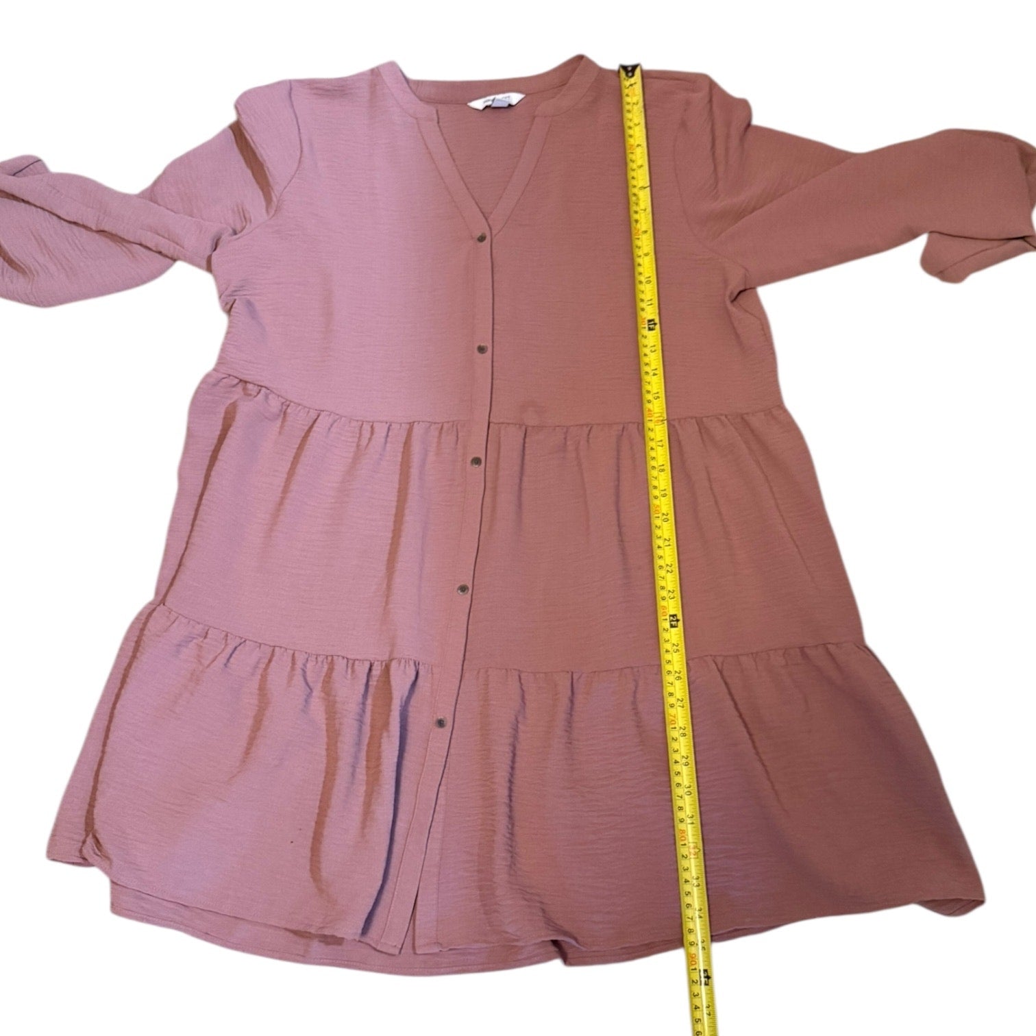 Pink dress with a measuring tape on a white background