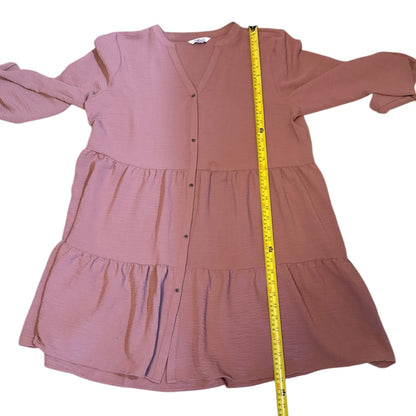 Pink dress with a measuring tape on a white background