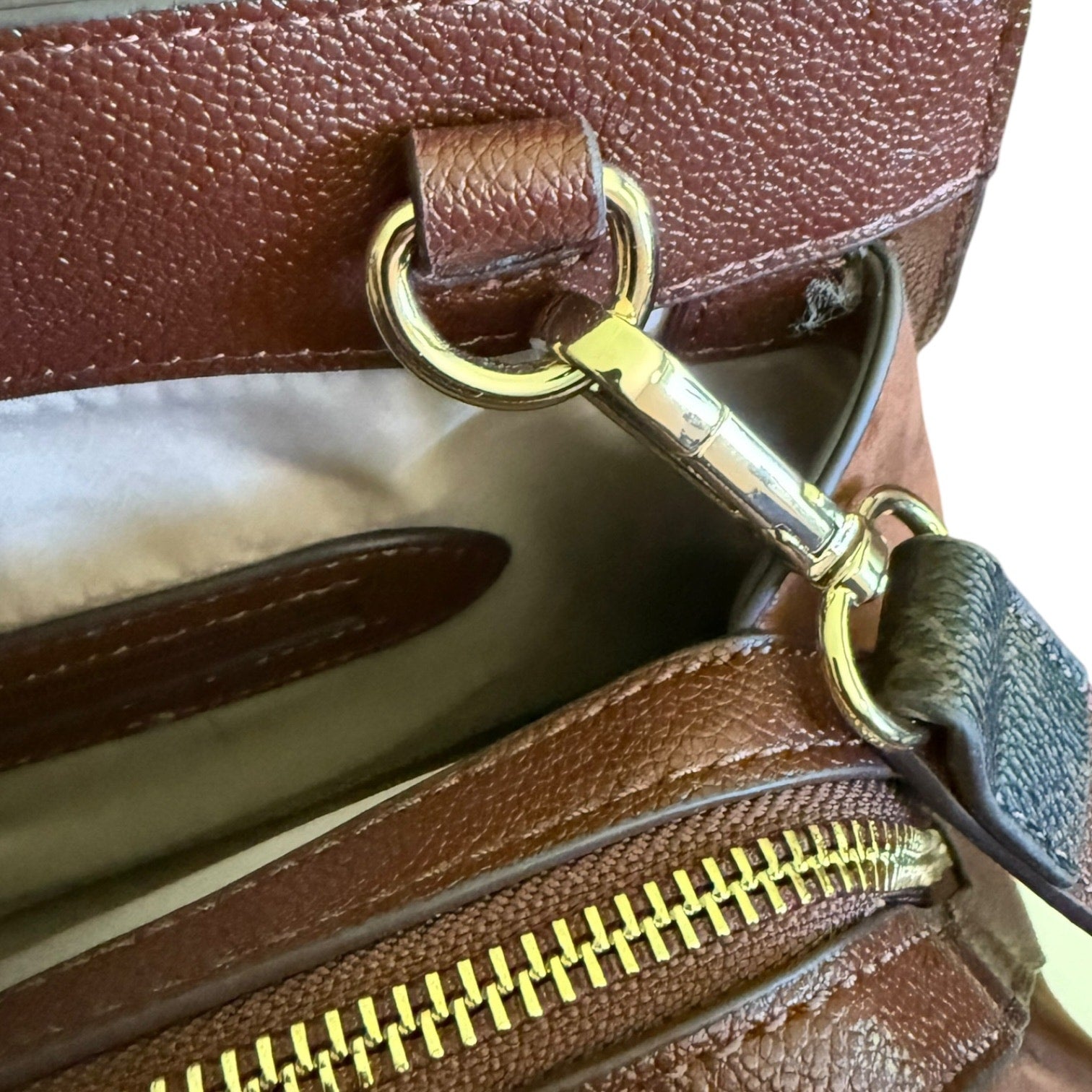 Brown leather handbag with gold zipper and clasp