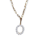 Gold chain necklace with a pearl pendant on a white background