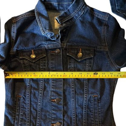 Blue denim jacket with a measuring tape across it on a white background