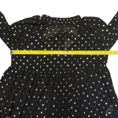 Black polka dot dress with a yellow measuring tape across the chest