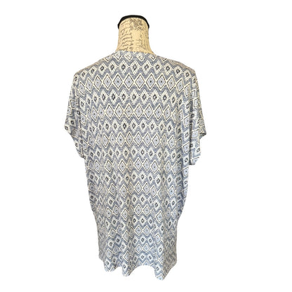 A short-sleeve tunic top with an all-over geometric diamond pattern in blue and white, displayed on a mannequin torso against a plain white background.