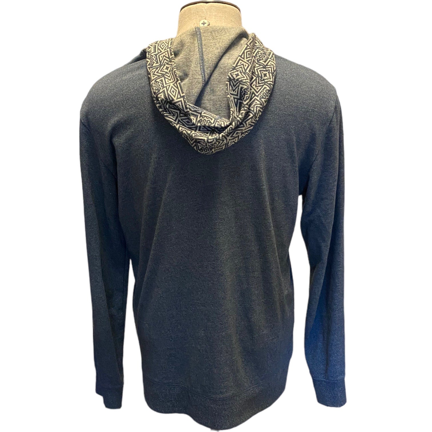 Blue hoodie with patterned hood on a mannequin against a white background