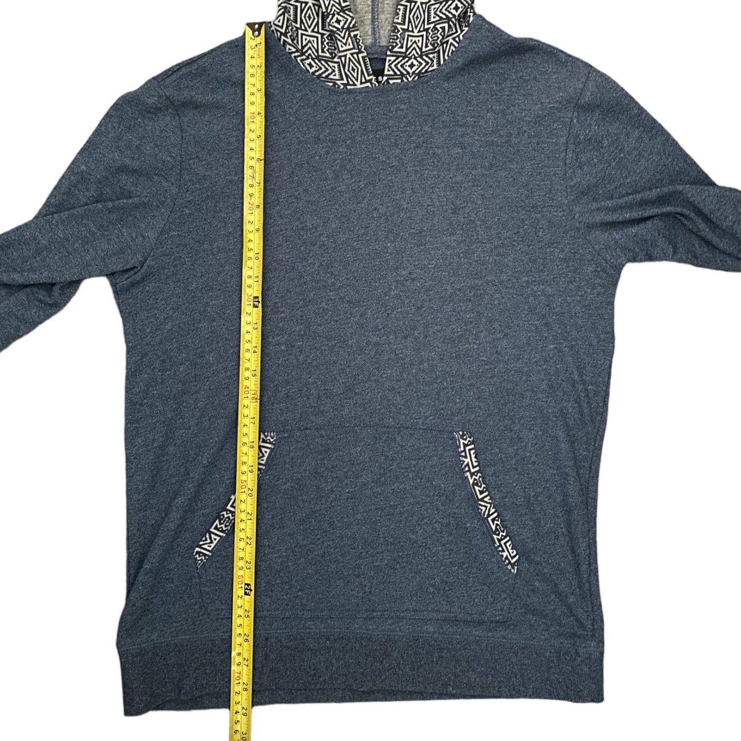 Blue hoodie with a measuring tape for size reference on a white background
