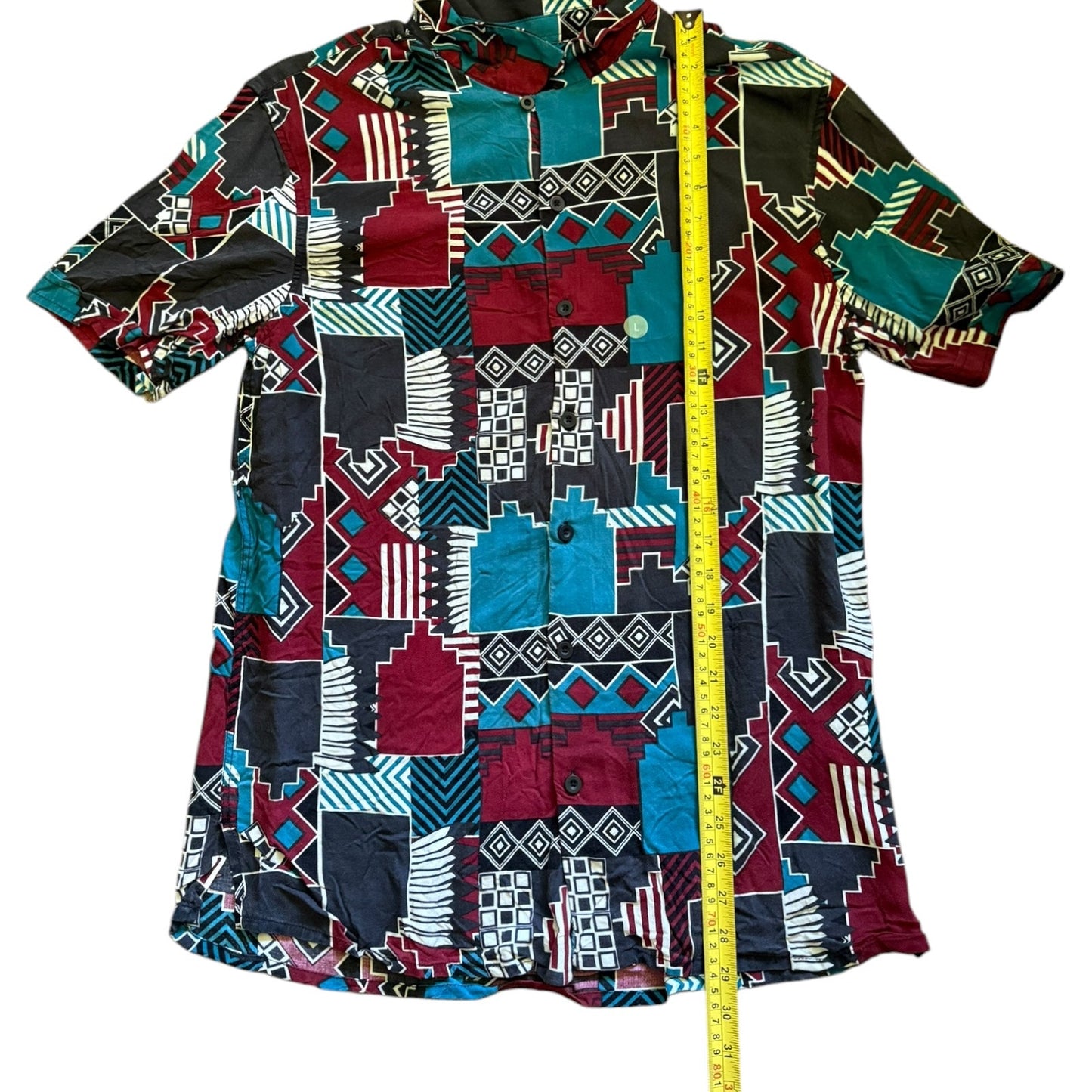 Colorful patterned shirt with a measuring tape for size reference on a white background