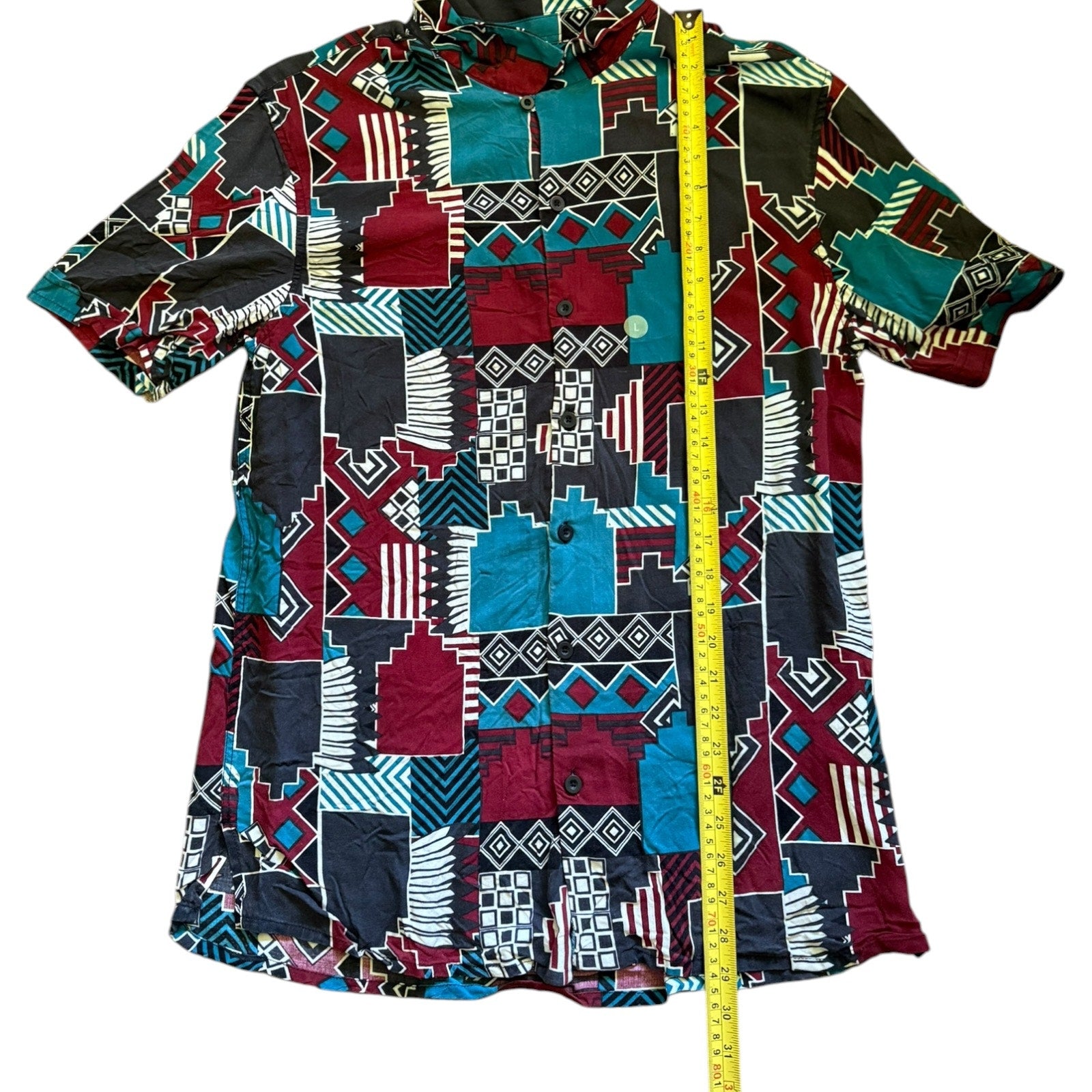 Colorful patterned shirt with a measuring tape for size reference on a white background