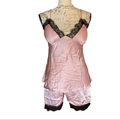 Pink satin pajamas with lace trim on a mannequin against a white background