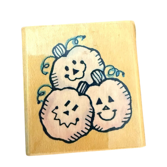 Wooden stamp with pumpkin designs on a yellow background