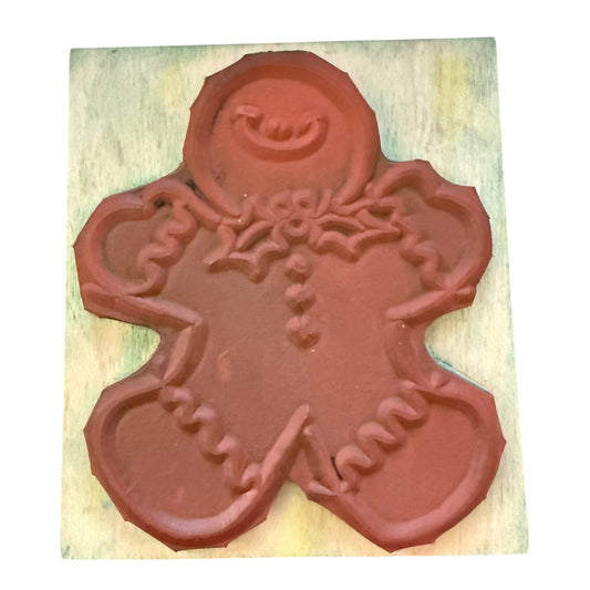Red gingerbread man cookie stamp on a wooden block